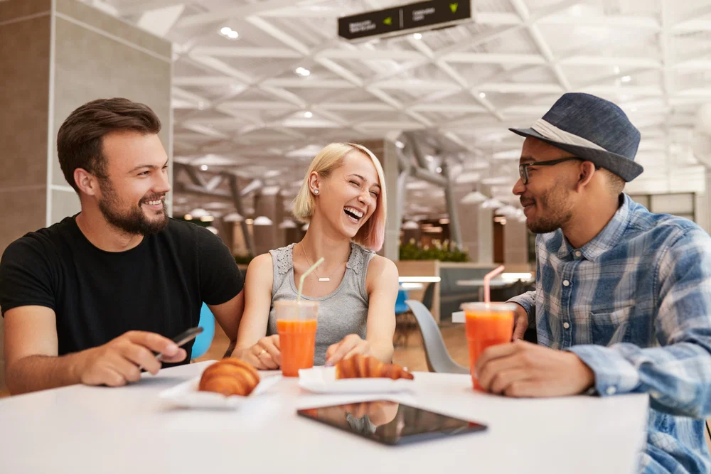 Group of friendly multi-ethnic young people meeting at airport relaxed and chatting